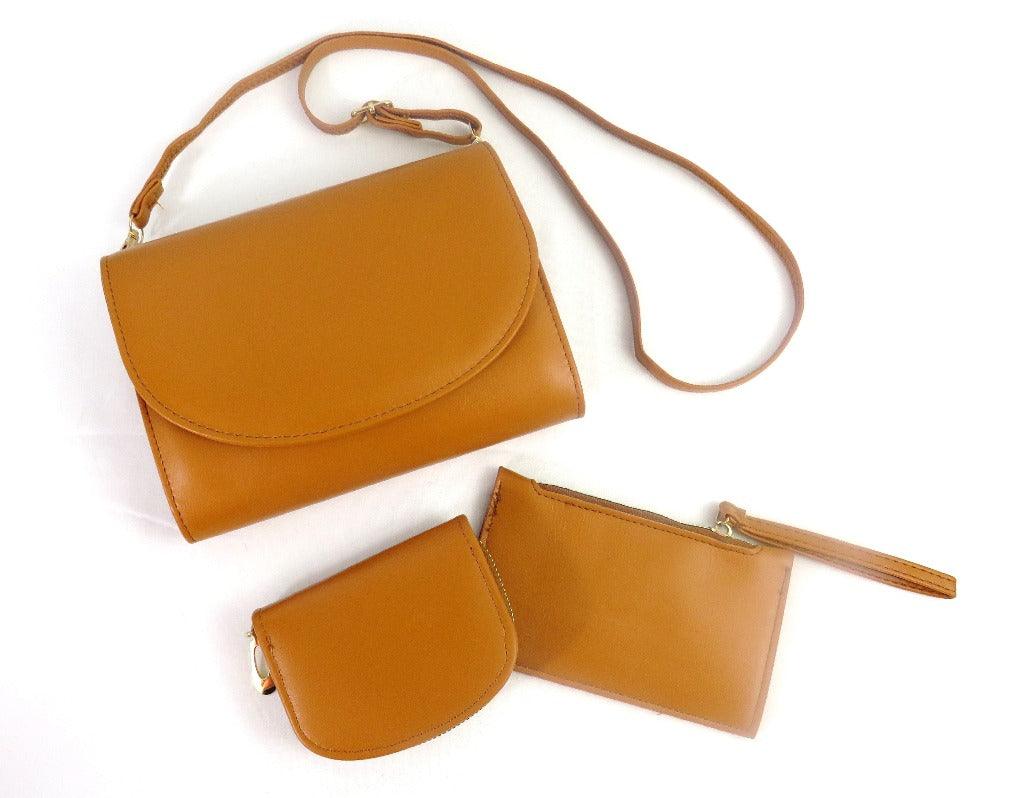 Camel clutch purse with an strap, coin purse and lipstick purse on a white background