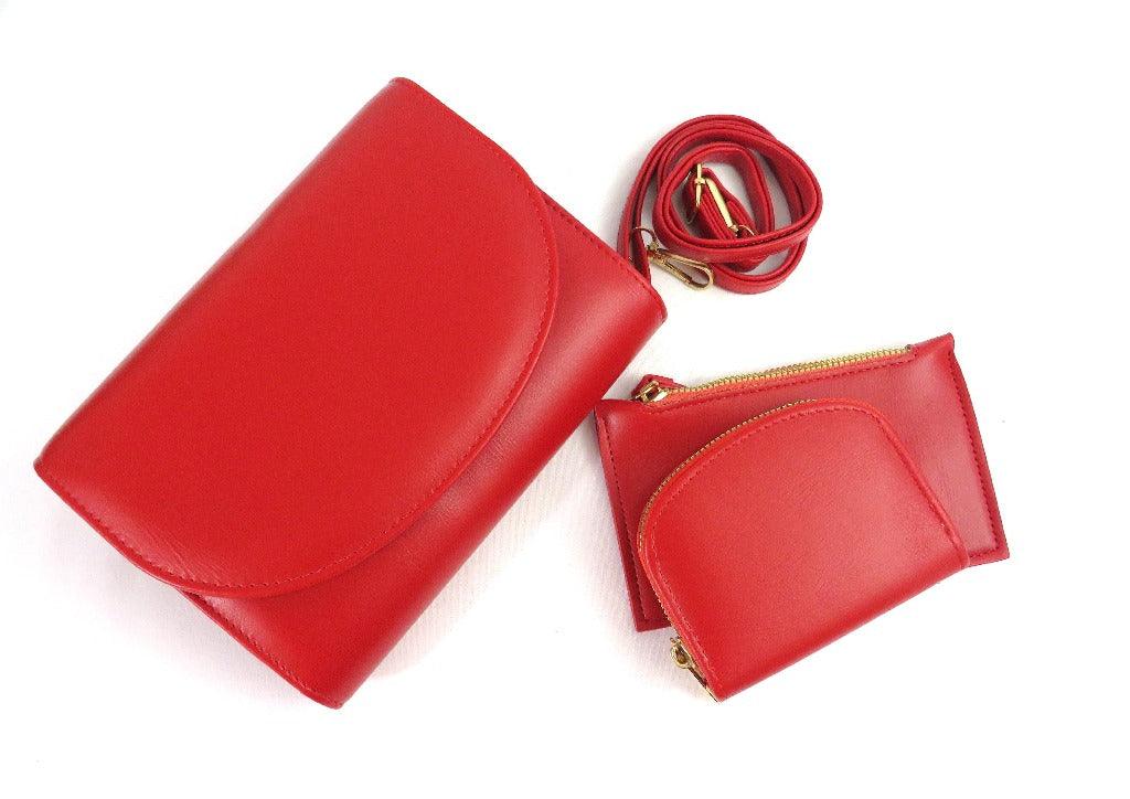 Red clutch purse with an strap, coin purse and lipstick purse on a white background