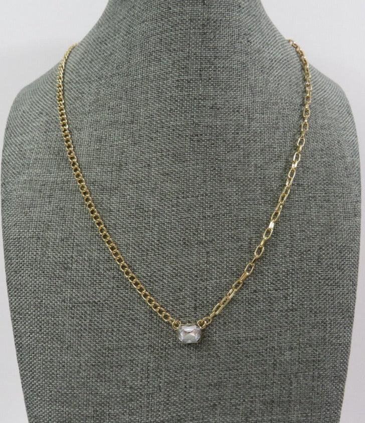 bright stone necklace in white with gold chains of 2 different styles on a necklace mannequin on a white background 
