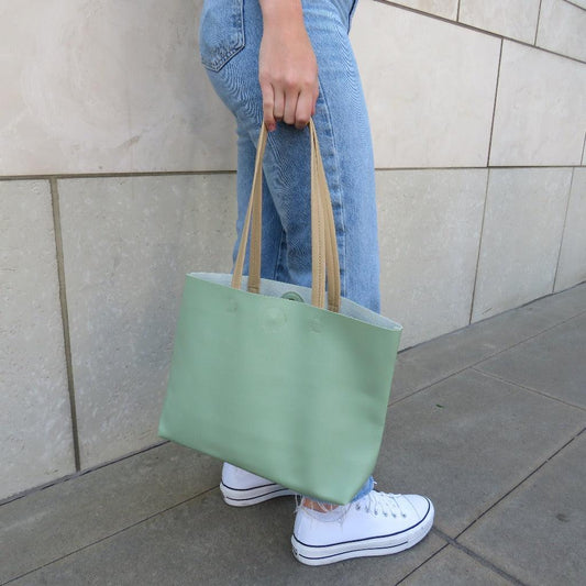 Girl standing holding the green Madison Work Tote