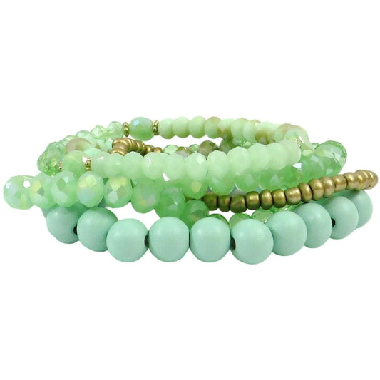 4 beaded mint strand bracelets with one gold beaded bracelet staked on a white background