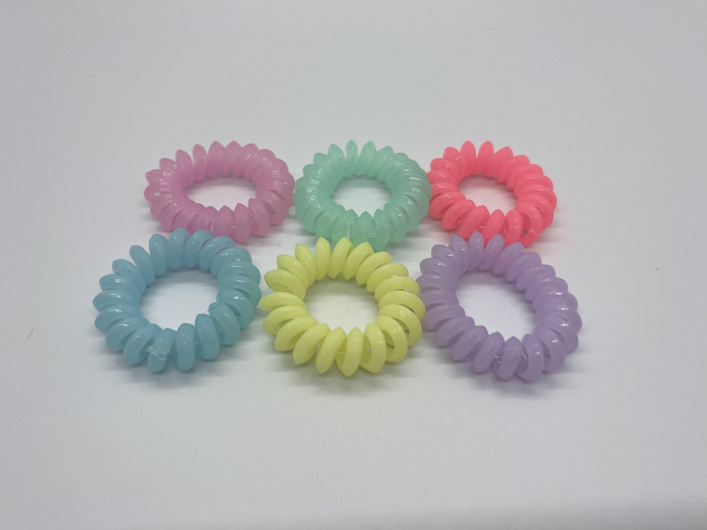 a set of the 6 bright color hair ties on a white background