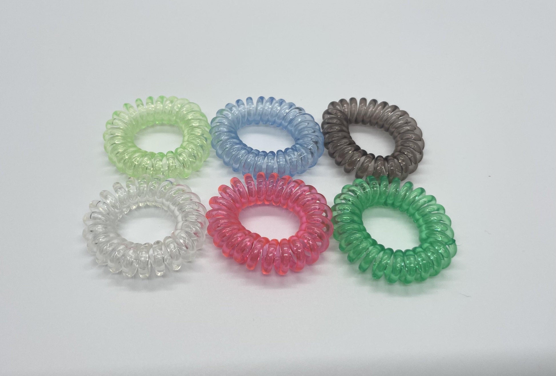 a set of the 6 clear color hair ties on a white background