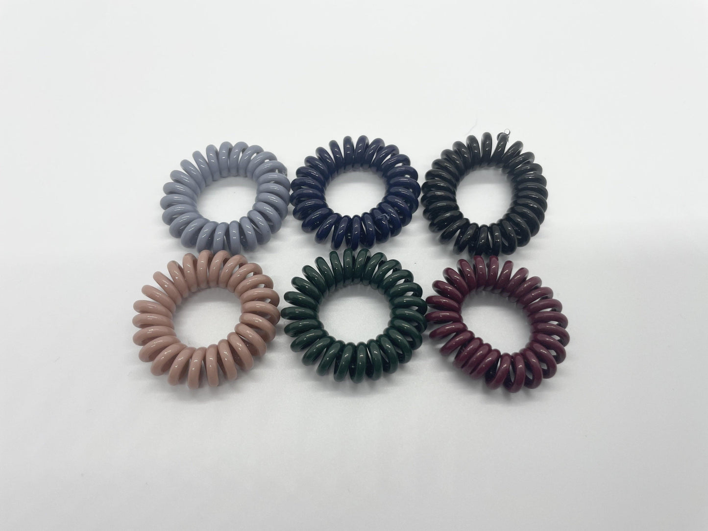 a set of the 6 dark matte color hair ties on a white background