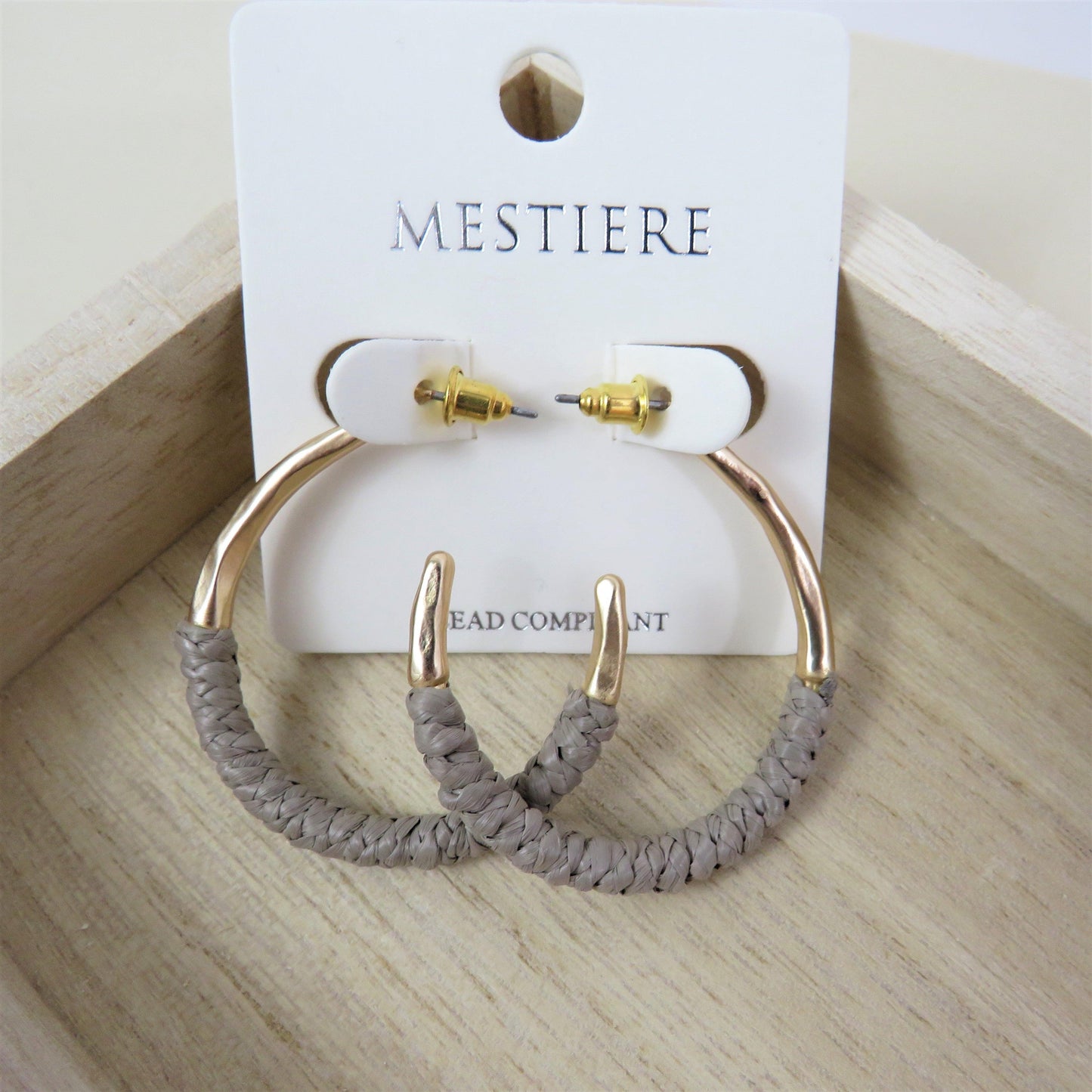Greige and gold rattan wrapped hoops on a wood backround