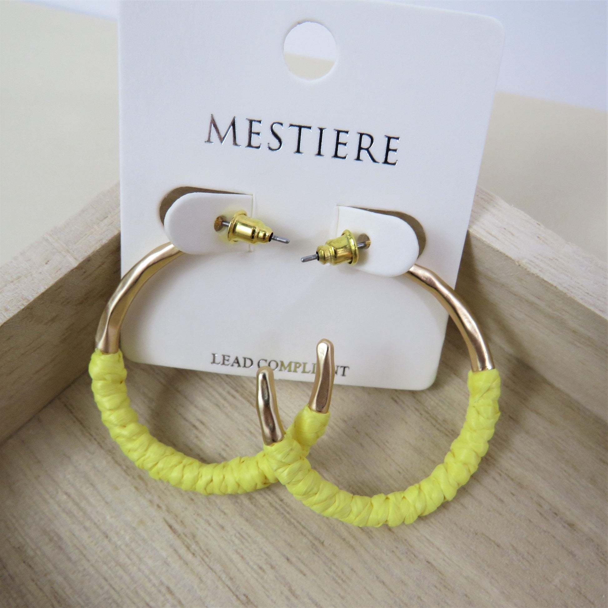 Yellow and gold rattan wrapped hoops on a wood backround