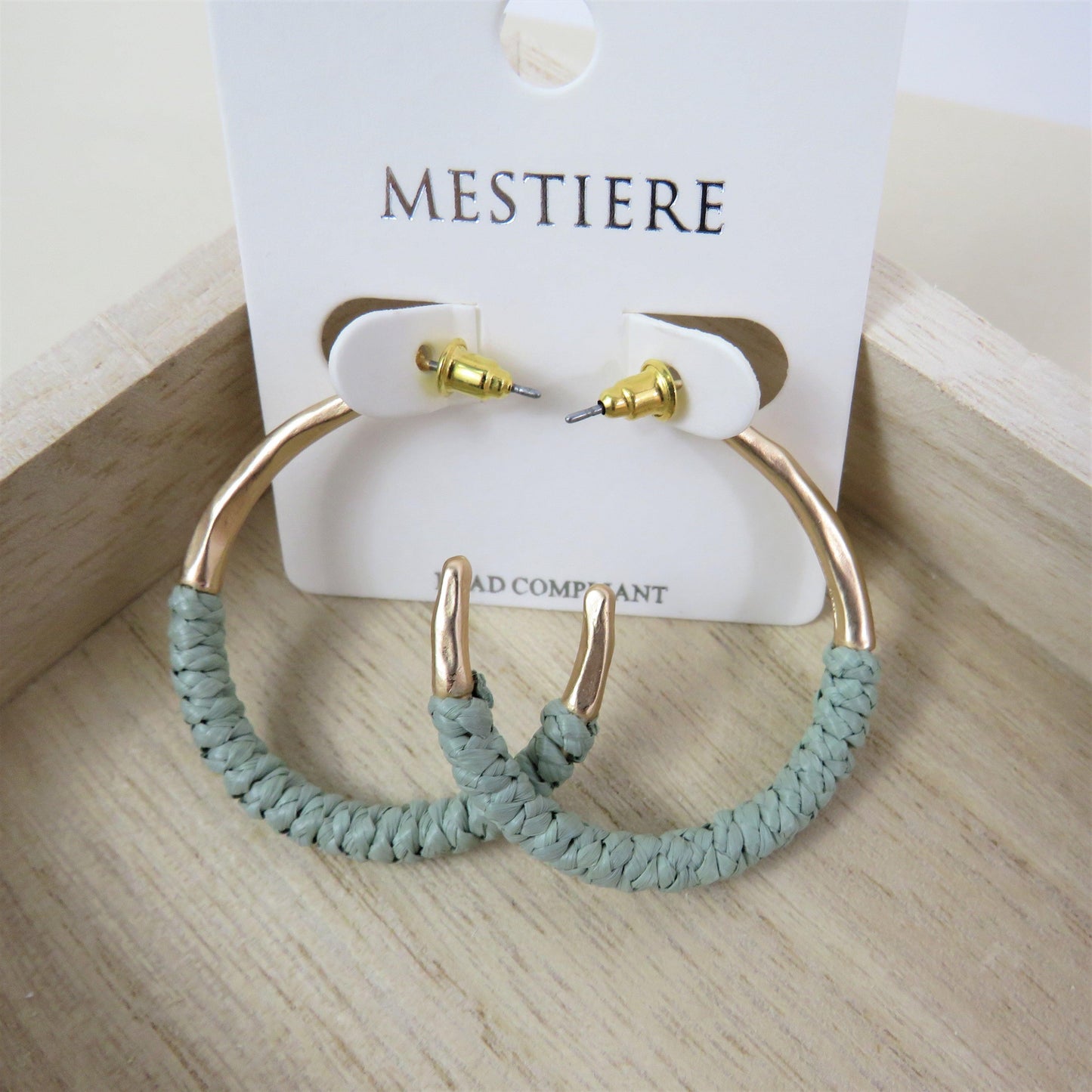 Moss and gold rattan wrapped hoops on a wood backround