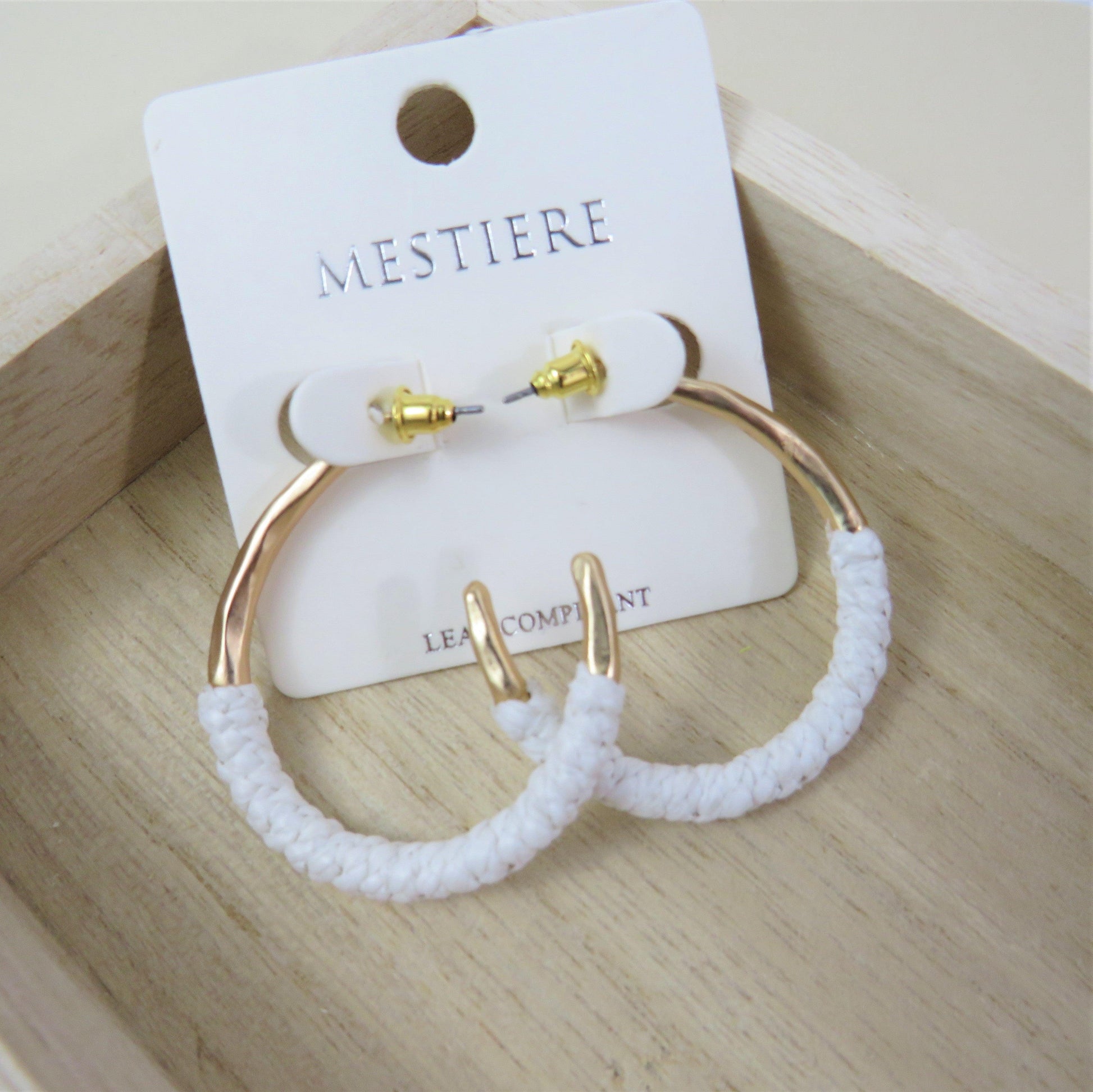 White and gold rattan wrapped hoops on a wood backround