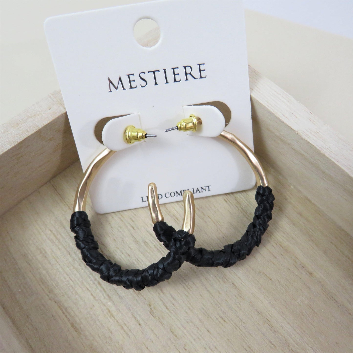Black and gold rattan wrapped hoops on a wood background